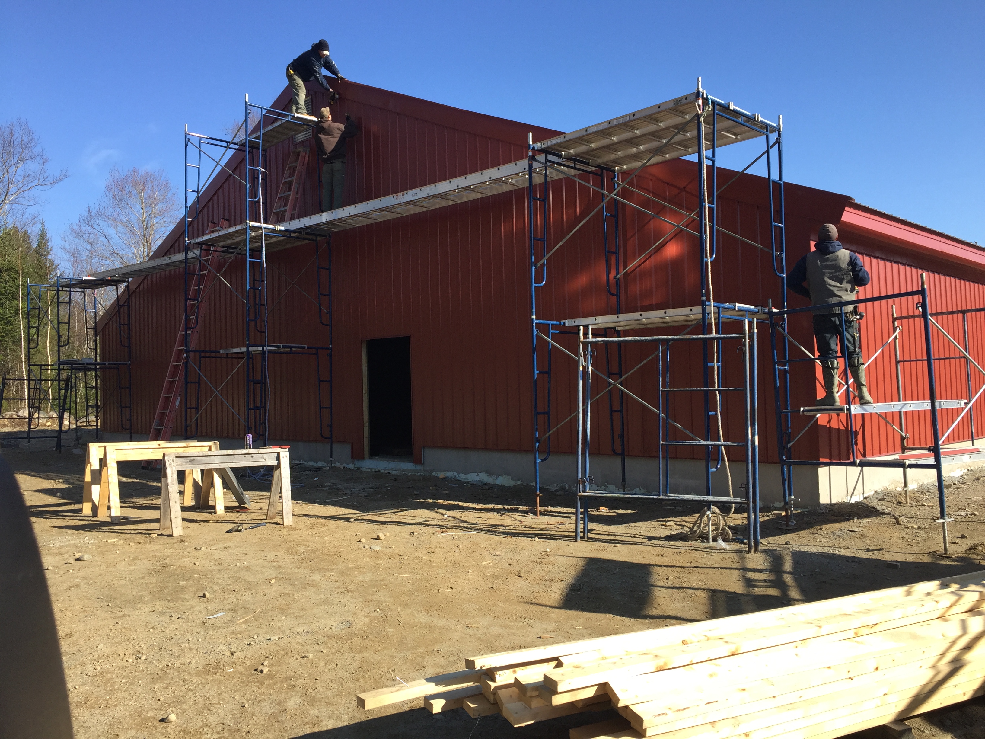 scaffolding on the exterior of red steel building by Steel Bolt Construction